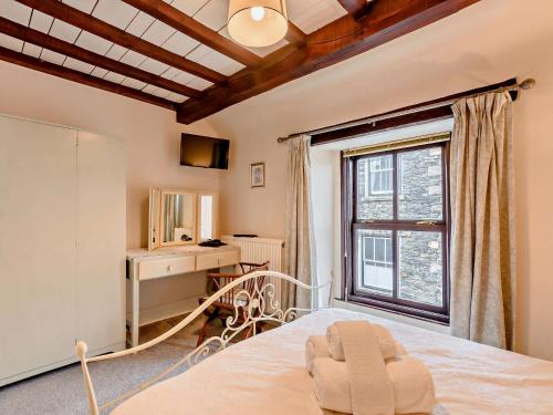ein Schlafzimmer mit einem Bett, einem Schreibtisch und einem Fenster in der Unterkunft 3 Bed in Bowness-On-Windermere 93088 in Bowness-on-Windermere
