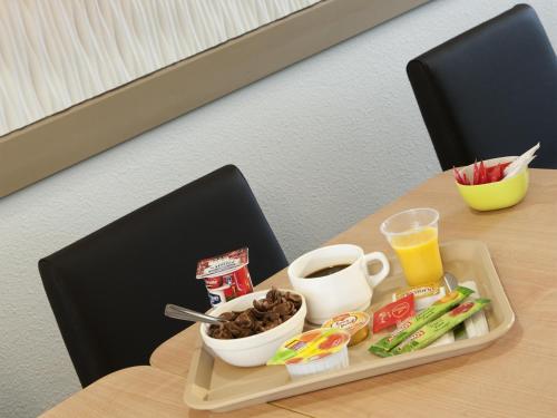 Una bandeja de comida en una mesa con café y bocadillos. en ibis budget Toulouse Aeroport, en Blagnac