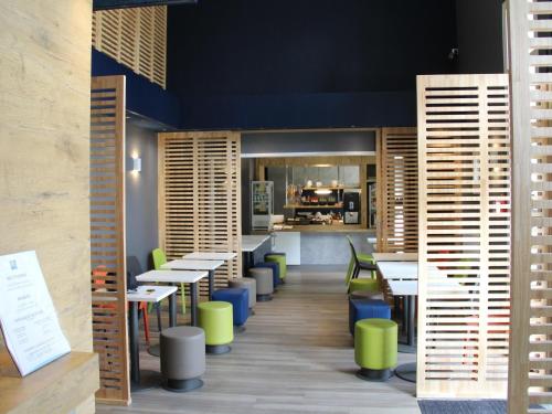 Un restaurante con mesas y sillas y un mostrador. en Ibis Budget Redon, en Redon