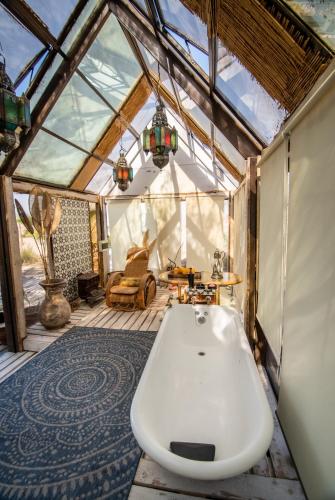 a bathroom with a tub in a glass house at Espacio El Sol in La Tirana