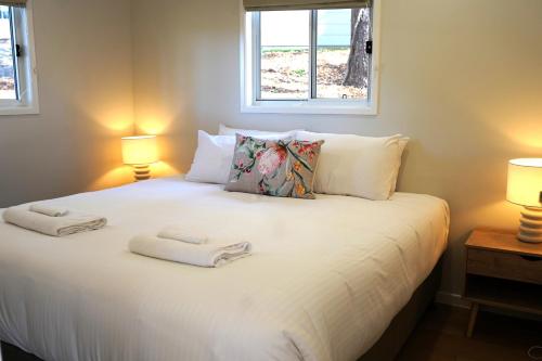 a bedroom with a white bed with two towels on it at Sunshine Coast Hinterland Retreat - Yandina Station in Yandina Creek