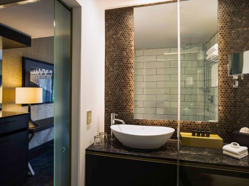 un baño con lavabo y espejo en Mövenpick Hotel Wellington, en Wellington
