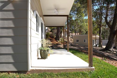 a porch of a house with a potted plant at Sunshine Coast Hinterland Retreat - Yandina Station in Yandina Creek