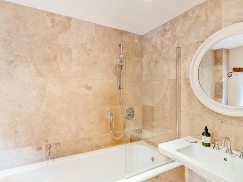 a bathroom with a shower and a tub and a sink at 4 Bed in Grassington 92954 in Cracoe