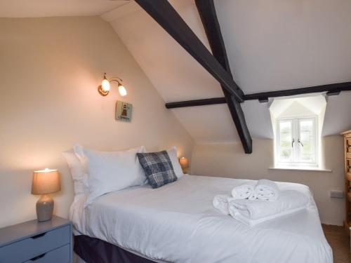 een slaapkamer met een wit bed met handdoeken erop bij 3 Bed in Bude 86887 in Kilkhampton