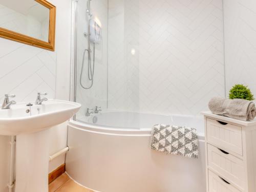 a white bathroom with a tub and a sink at 4 Bed in Llandovery 82440 in Llanfair-ar-y-bryn