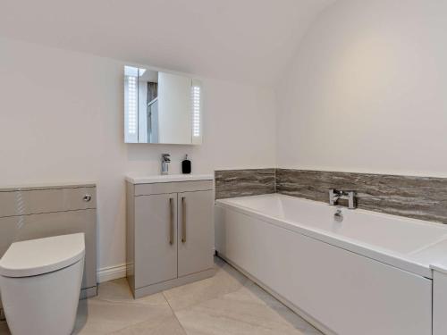 a bathroom with a tub and a toilet and a sink at 4 Bed in Bishops Castle 94072 in Bishops Castle