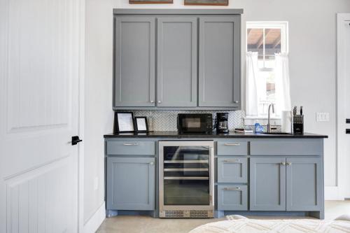 a kitchen with a blue island with a microwave at Brazos - A Birdy Vacation Rental in Fredericksburg