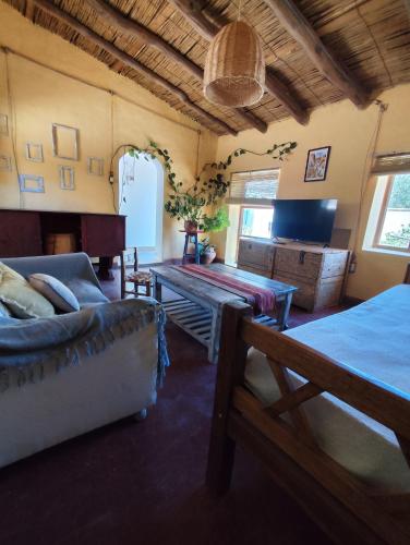 ein Wohnzimmer mit Sofa und Tisch in der Unterkunft Casa de Altura in Tilcara