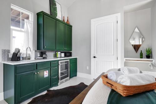 a kitchen with green cabinets and a dog bed in it at Llano - A Birdy Vacation Rental in Fredericksburg