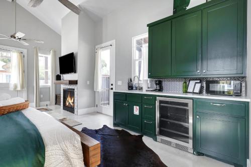 a green kitchen with a bed and a fireplace at Llano - A Birdy Vacation Rental in Fredericksburg