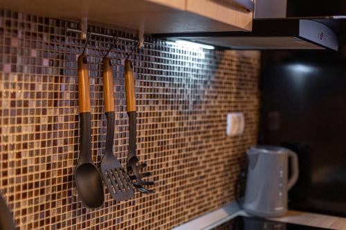 蒂米什瓦拉MARA Luxury Golden ApArt Hotel - ULTRACENTRAL with Free Parking的厨房配有挂在墙上的厨具