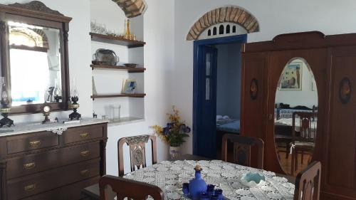 a dining room with a table and a kitchen at Ioanna's in Panormos