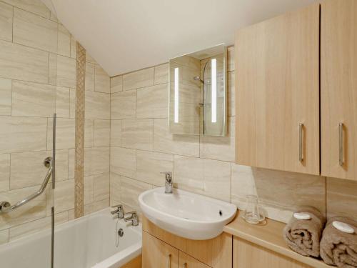 a white bathroom with a sink and a bath tub at 1 bed in Stamford Bridge 92093 in High Catton
