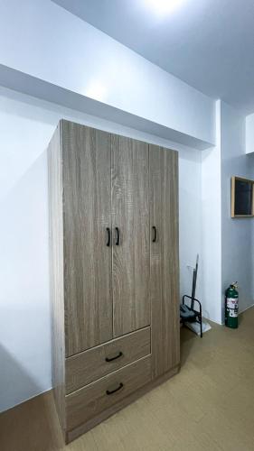 a large wooden cabinet in the corner of a room at Warm Urban Studio with modern design in Molo