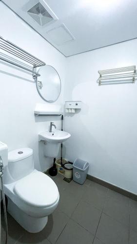 a white bathroom with a toilet and a sink at Warm Urban Studio with modern design in Molo
