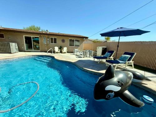 a swimming pool with an inflatable animal in the water at Endless Summer, Pool, Theatre, Boat Parking, Walk to London Bridge! in Lake Havasu City
