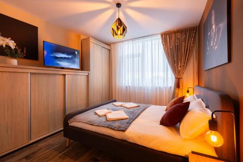 ティミショアラにあるMara Luxury Golden Art, Apartment PLUS Free Parkingのベッドとタオル2枚のある寝室