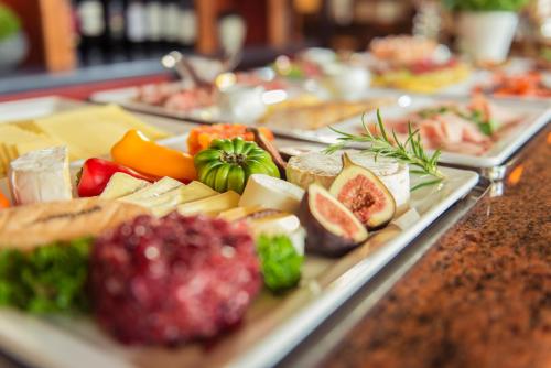 a buffet line with different types of food on plates at Hotel Wegner - T h e culinary art hotel in Hannover