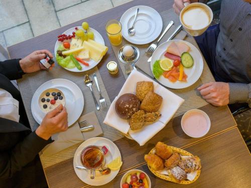 a group of people sitting at a table with food at Novotel Nürnberg Centre Ville in Nürnberg