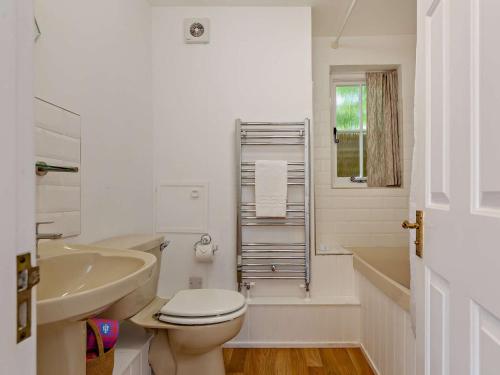 a white bathroom with a toilet and a sink at 1 Bed in Minehead 90923 in Minehead