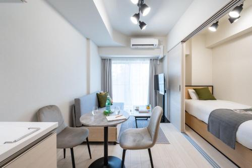 a hotel room with a bed and a table and chairs at Daffitto Oshiage II in Tokyo