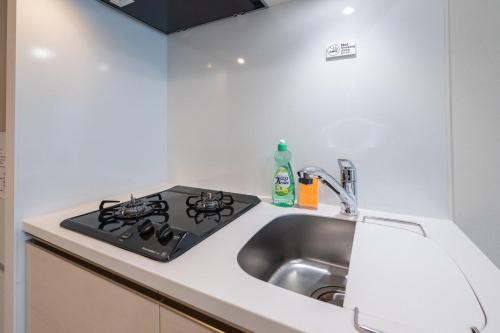 a kitchen with a sink and a stove at Daffitto Oshiage II in Tokyo