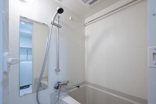 a bathroom with a shower and a sink at Daffitto Oshiage II in Tokyo