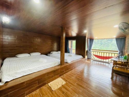 a bedroom with two beds and a wooden wall at Cat Tien Nature Hotel in Cat Tien