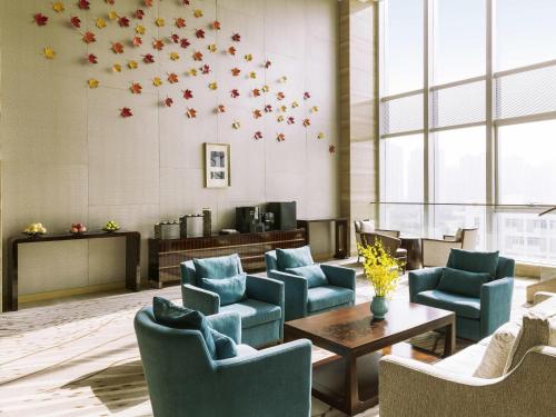 een wachtkamer met blauwe stoelen en een tafel bij Pullman Changshu Leeman in Changshu
