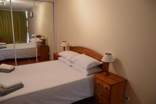 a bedroom with a bed and a mirror at Portugal Algarve Beach Apartment in Portimão