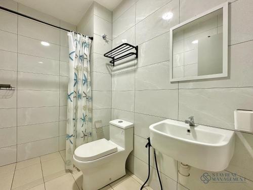 a white bathroom with a toilet and a sink at Amber Cove Melaka Sea View by Stayrene in Melaka