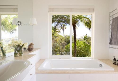 ein weißes Badezimmer mit großer Badewanne und Fenster in der Unterkunft Salt in Palm Beach