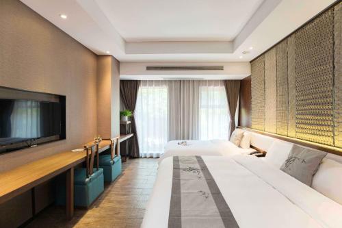 a hotel room with two beds and a flat screen tv at Confucius Temple Yisu Hotel in Gaoqiao