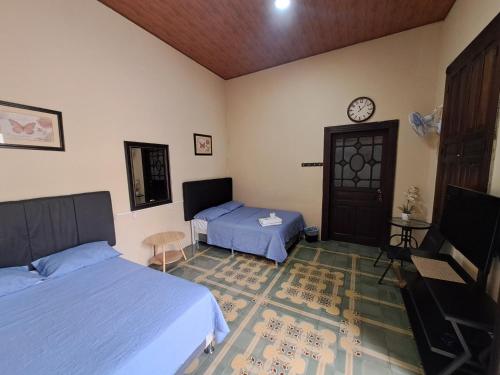 Un dormitorio con dos camas y un reloj en la pared. en Hotel Prada, en Las Victorias