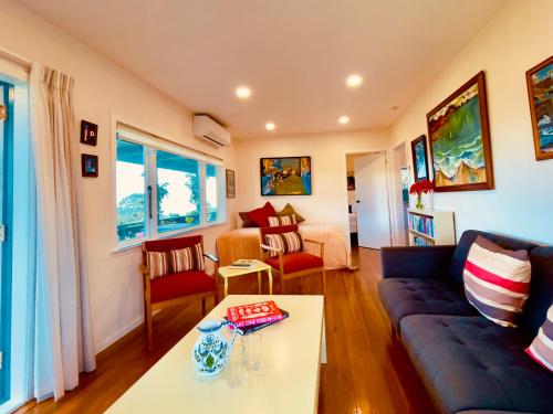 a living room with a couch and a table at The Shearer's Cottage, Matauri Bay Retreat in Matauri Bay