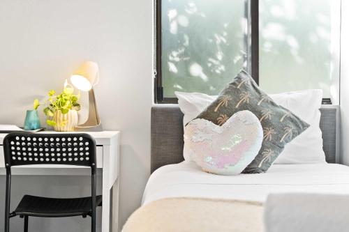 a bedroom with a bed with a heart pillow on it at Cozy King Single Room - Near Station & Olympic Park - Shared Bathroom in Rookwood Station
