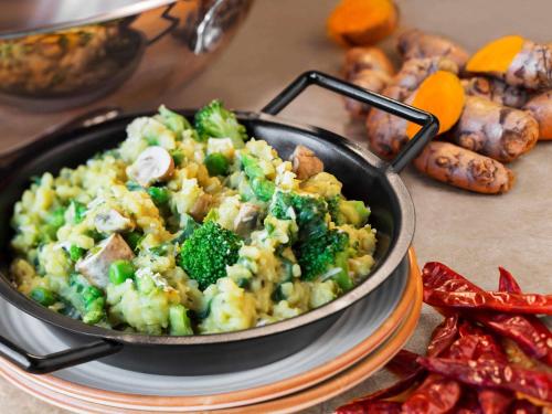a pan of food on a table with broccoli and mushrooms at ibis Chennai City Centre - An Accor Brand in Chennai