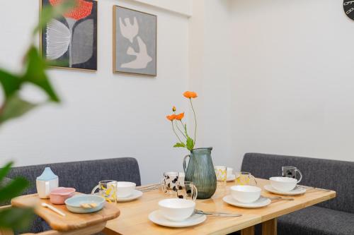a wooden table with cups and saucers on it at KOTOBUKI House - Perfect for Groups - 3 Bedrooms, 3 Baths in Tokyo