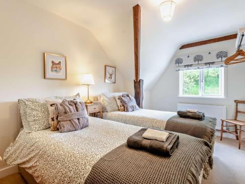 a bedroom with two beds and a window at 3 Bed in Godshill Wood 94495 in Godshill