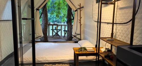 a room with a bed and a table and a view at Papaya Resort Nong Khiaw in Nongkhiaw