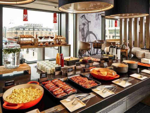Una línea de buffet con muchos tipos diferentes de comida. en ibis Cambridge Central Station, en Cambridge