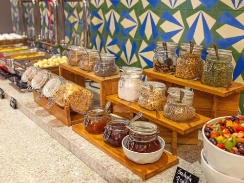 Una exhibición de comida en frascos en estantes de madera. en Mercure Jundiai Shopping, en Jundiaí