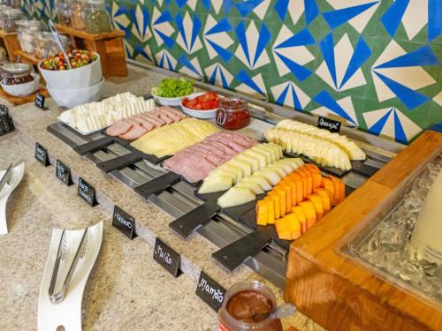 Un buffet con diferentes tipos de comida en una mesa. en Mercure Jundiai Shopping, en Jundiaí