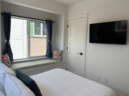 a bedroom with a bed and a tv and a window at Cozy 3 Bedroom Denver Home by Mile High Stadium and Downtown! in Denver