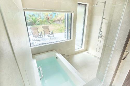 a bathroom with a tub and a shower with a window at COCO VILLA 九十九里一宮-Sauna- in Ichigaya