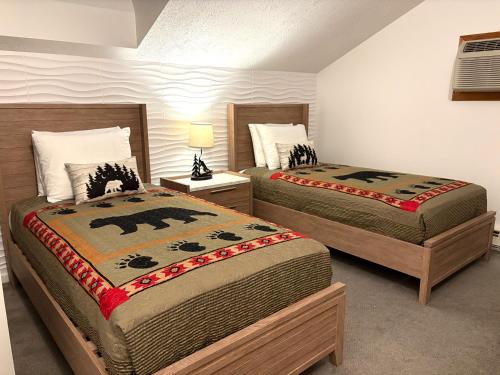 two beds in a room with two beds sidx sidx sidx sidx at Cozy Attitash Getaway-1BR-Pool-Walk to Attitash in Bartlett