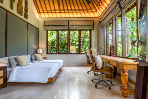 une chambre avec un lit, un bureau et des fenêtres dans l'établissement The Ubāri Bali - Luxury Riverside Escape, à Ubud