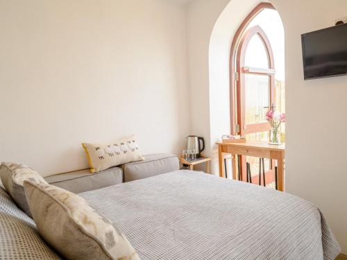 a bedroom with a bed and a couch and a window at 1 Bed in Hatherleigh 78799 in Hatherleigh