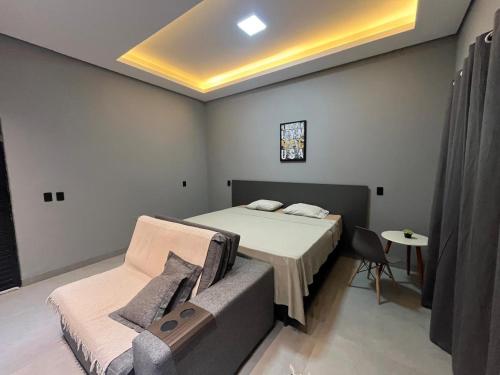 a bedroom with a bed and a couch in it at Studio Casa21 - Moderno e aconchegante in Cáceres